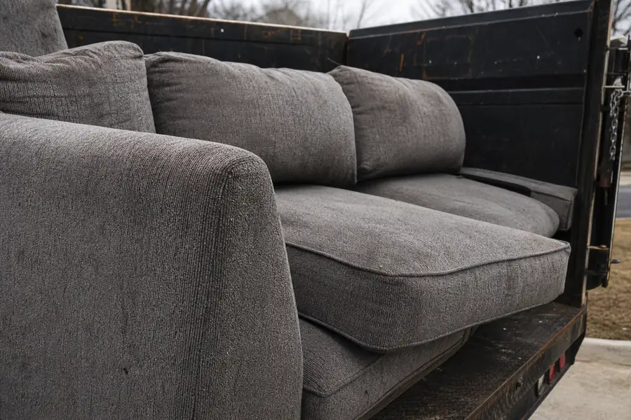 Sectional sofa into a junk removal truck