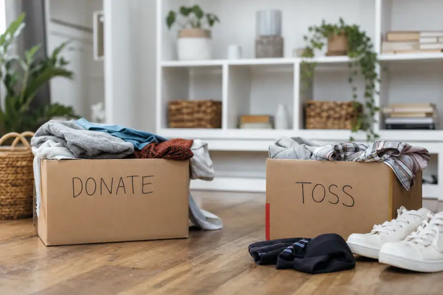 Bright organized living room with sorted donate and toss boxes