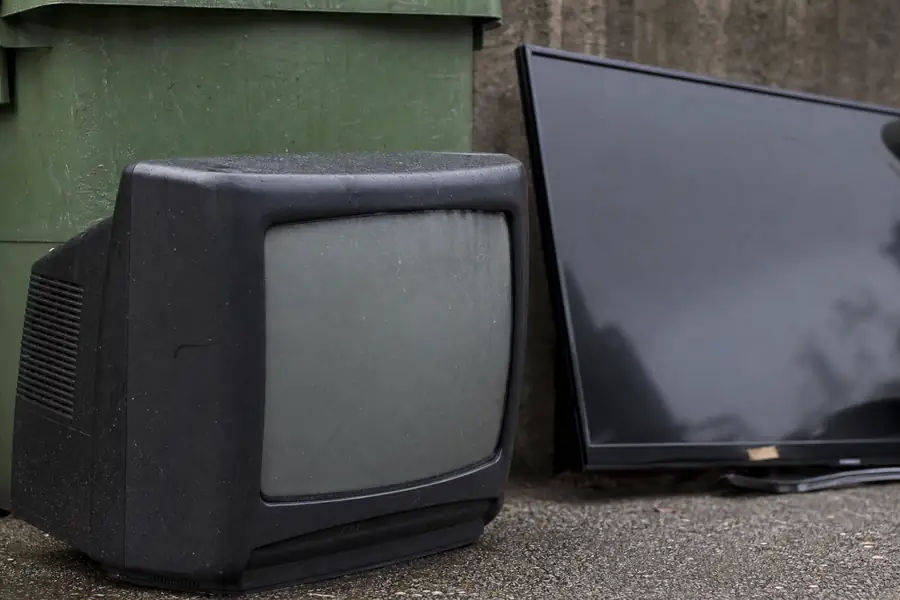 CRT television and flat screen by a recycling bin