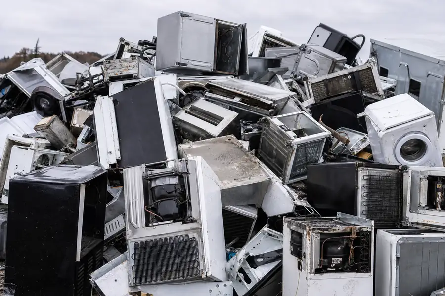 Pile of scrap metal appliances and electronics staged for recycling drop-off